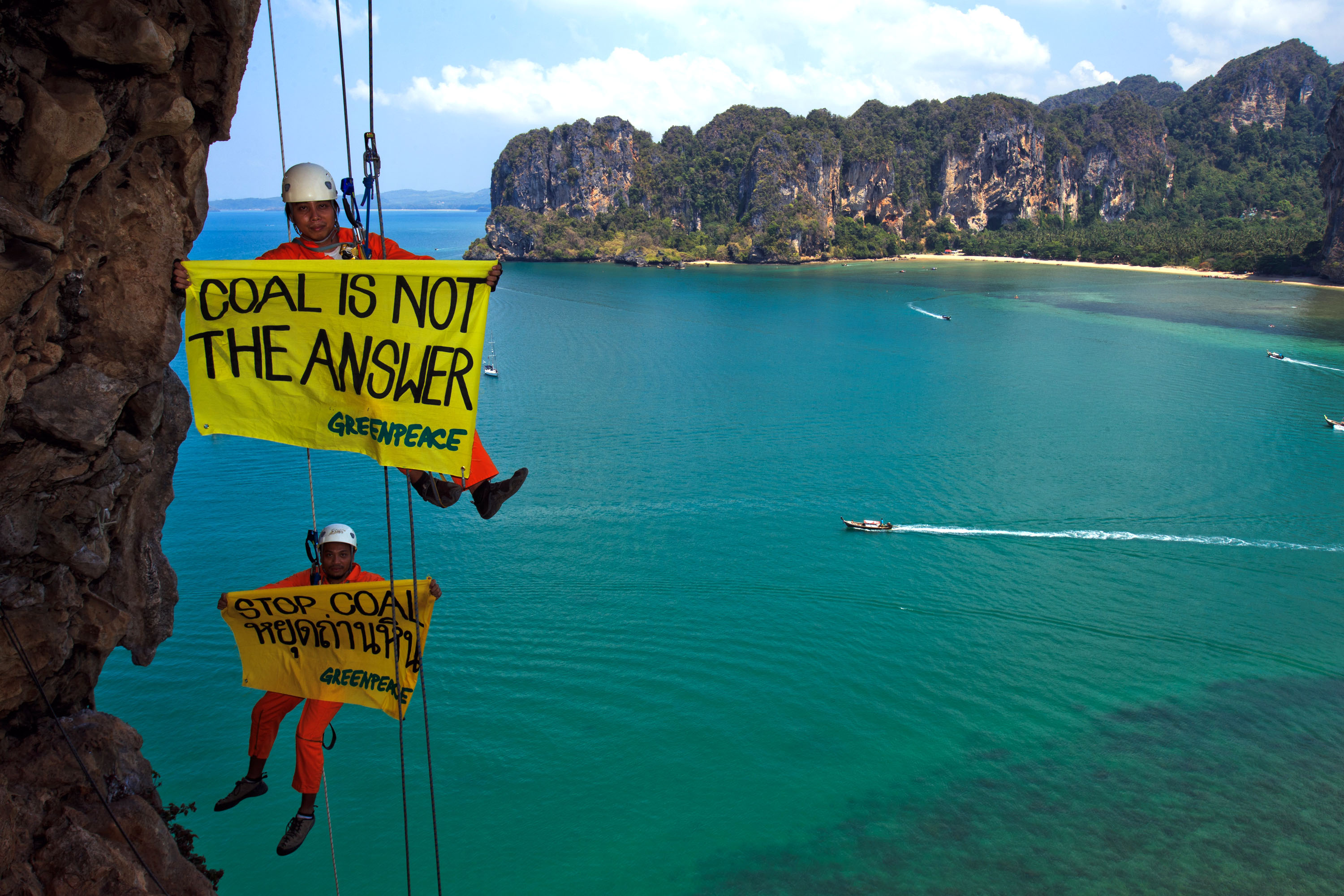 Krabi, Thailand. Greenpeace climbing activists hangs banner with a message of "STOP COAL (or COAL IS NOT THE ANSWER) at Rairay beach, admonishing government stop deceptive energy crisis discourse to go to new coal power plant. Photo by Athit Perawongmetha/Greenpeace.